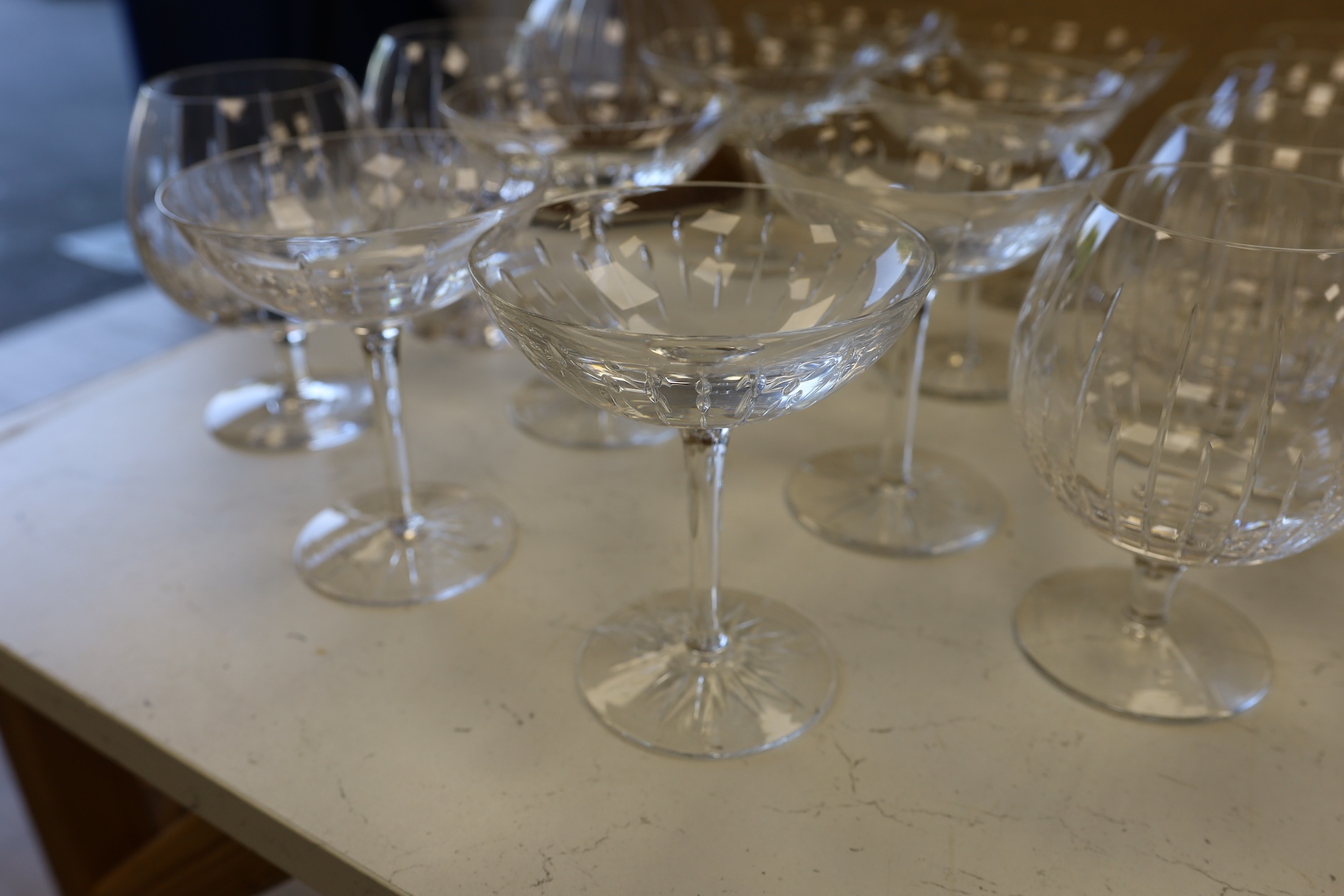 A Linley Glyndebourne pattern cut glass decanter with a silver mounted stopper, on a weighted wooden coaster stand, and a matching set of ten goblets, and eight champagne coupes, largest 30cm high. Condition - all in ver